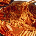 Budae Jjigae being served into bowls.