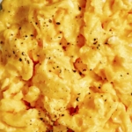 Scrambled eggs with salt and pepper on top.