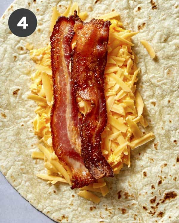 Bacon in a breakfast burrito before its rolled up.