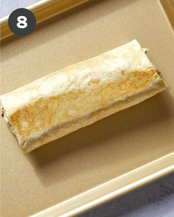 A breakfast burrito out of the oven crisped on the outside.