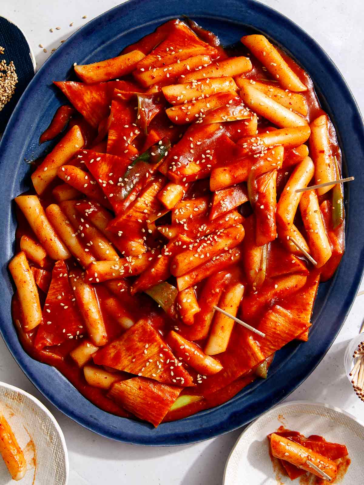 Tteokbokki, Korean rice cakes, recipe on a platter being served.