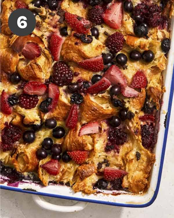 Bread pudding in a baking dish with berries.