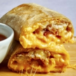 A breakfast burrito cut in half with cheese oozing out.