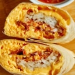 Breakfast burrito cut in half with salsa on the side.