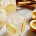 Classic lemonade recipe in glasses with ingredients around the side.