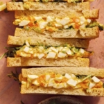 Egg salad sandwich recipe on a surface.