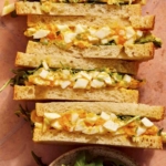 Egg salad sandwich recipe on a surface.