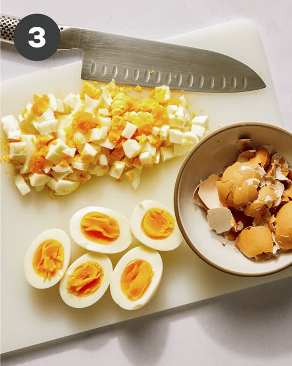 Hard boiled eggs being chopped to make egg salad sandwiches. 