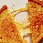 Perfect grilled cheese recipe close up on cheese pulls.