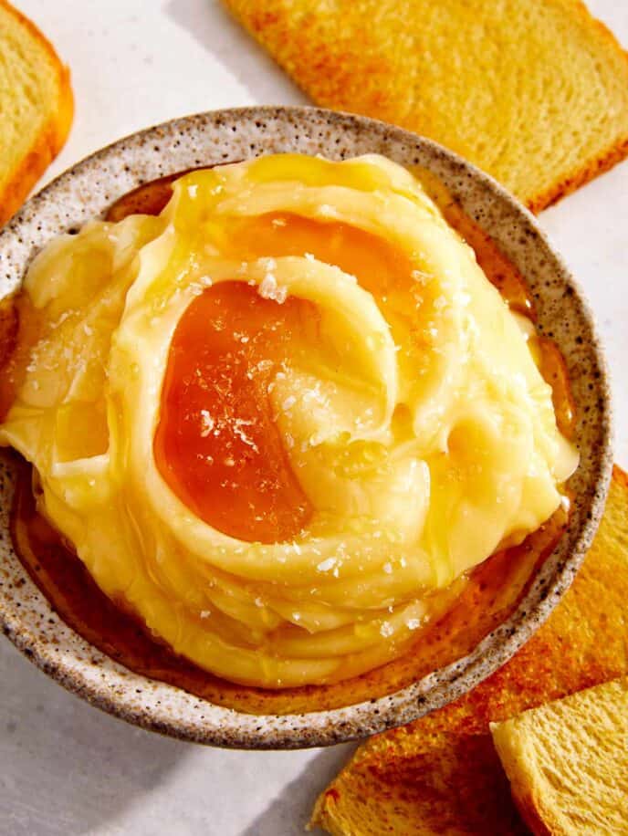 Honey butter in a bowl with toast on the side.