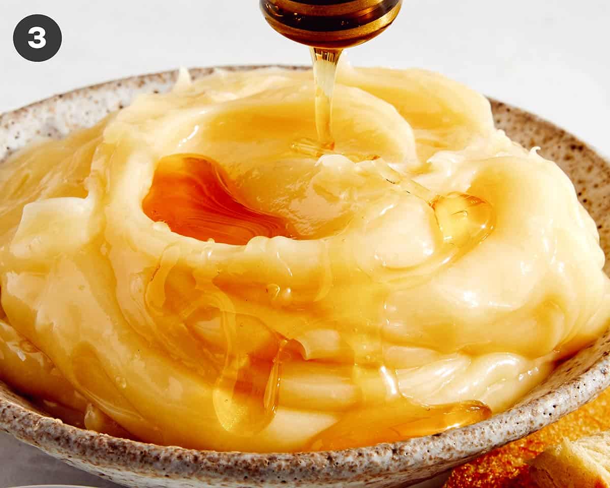 Honey butter in a bowl with honey and salt on top.