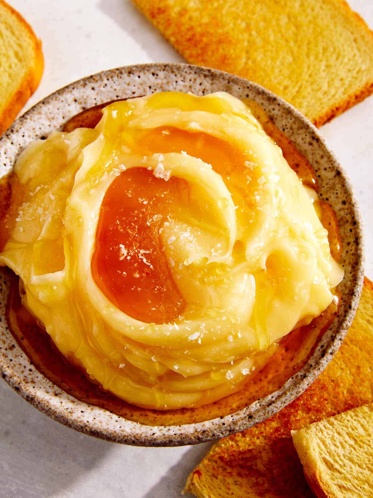 Honey butter in a bowl with toast on the side. 