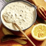 Tartar sauce recipe in a bowl with ingredients on the side.