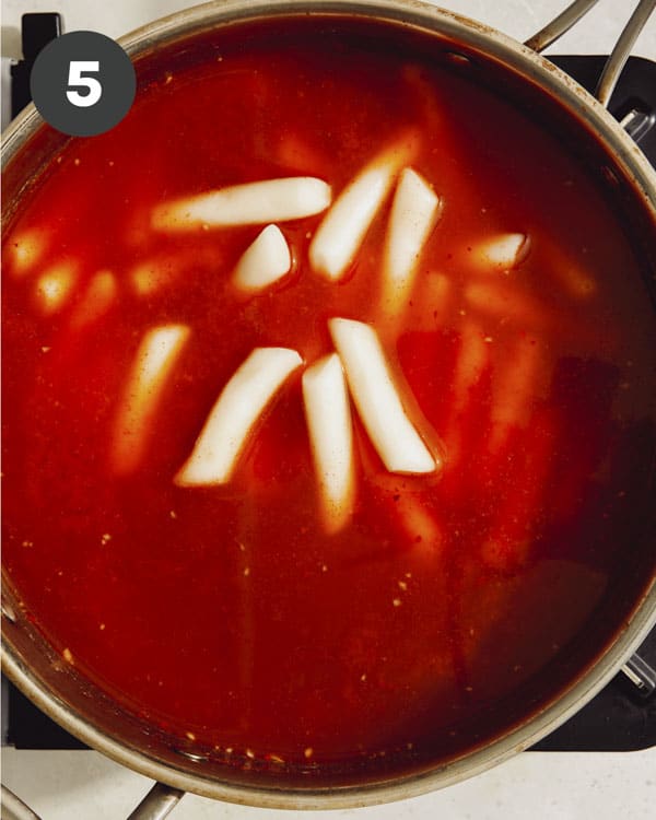 Tteokbokki recipe with rice cakes in a pot.
