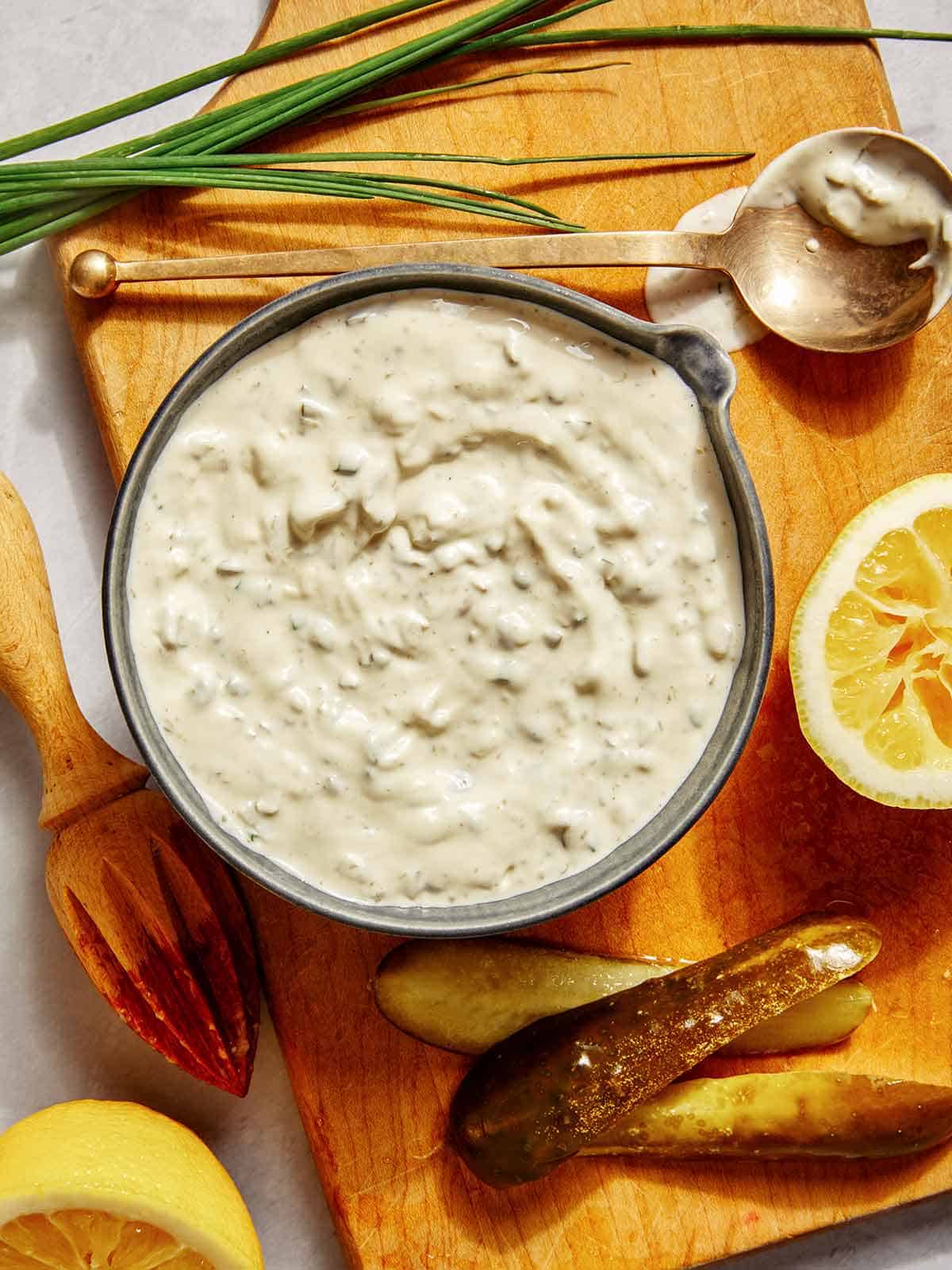 Tartar sauce recipe in a bowl with ingredients on the side. 