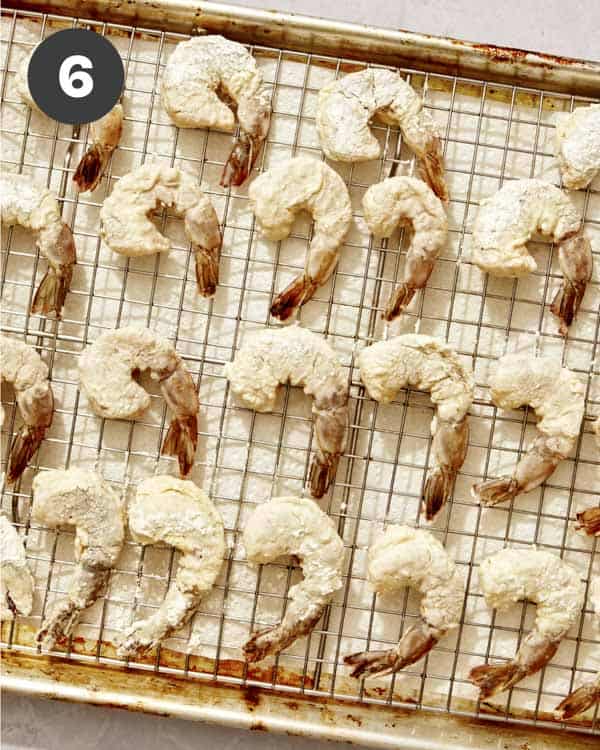 Bang bang shrimp coated and resting on a baking sheet. 