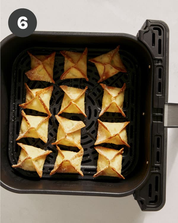 Air fryer crab rangoons freshly cooked in an air fryer. 