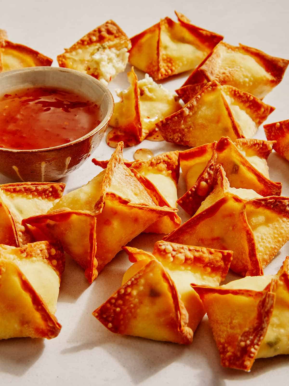 Air fryer crab rangoons with a dipping sauce on the side.