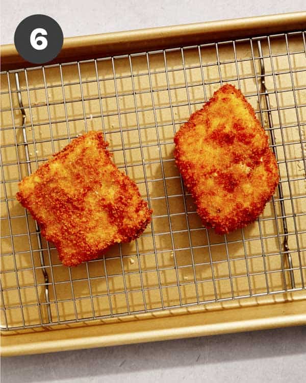 Freshly fried filet o fish resting on a baking sheet. 