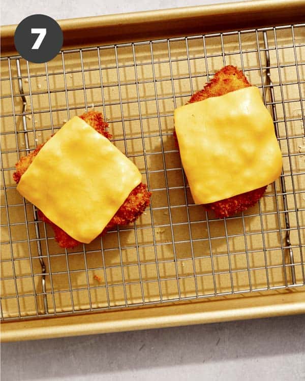 Filet o fish on a baking sheet with cheese on top. 