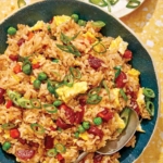 Fried rice in a bowl with green onions on the side.