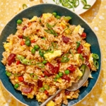 Fried rice in a bowl with green onions on the side.