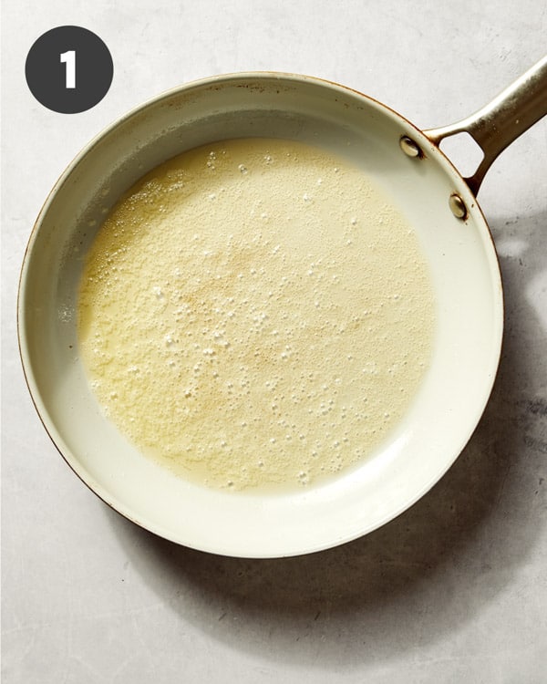 Melted butter in a skillet with breadcrumbs. 