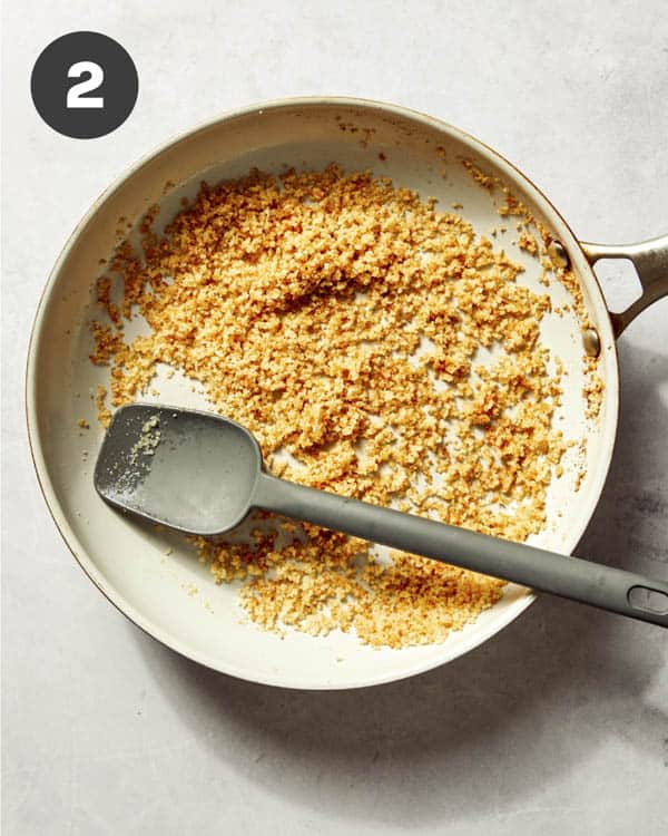 Breadcrumbs toasting in a skillet with butter.