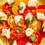 Caprese salad on a platter with mozzarella and basil.