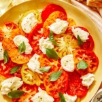 Caprese salad on a platter with mozzarella and basil.