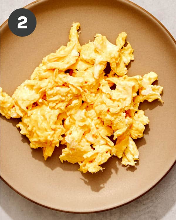 Scrambled eggs on a plate resting.