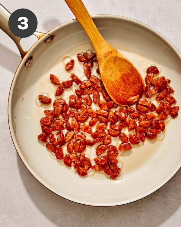 Sausage cooking in a skillet for fried rice.