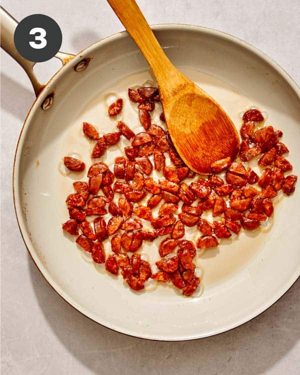 Sausage cooking in a skillet for fried rice. 