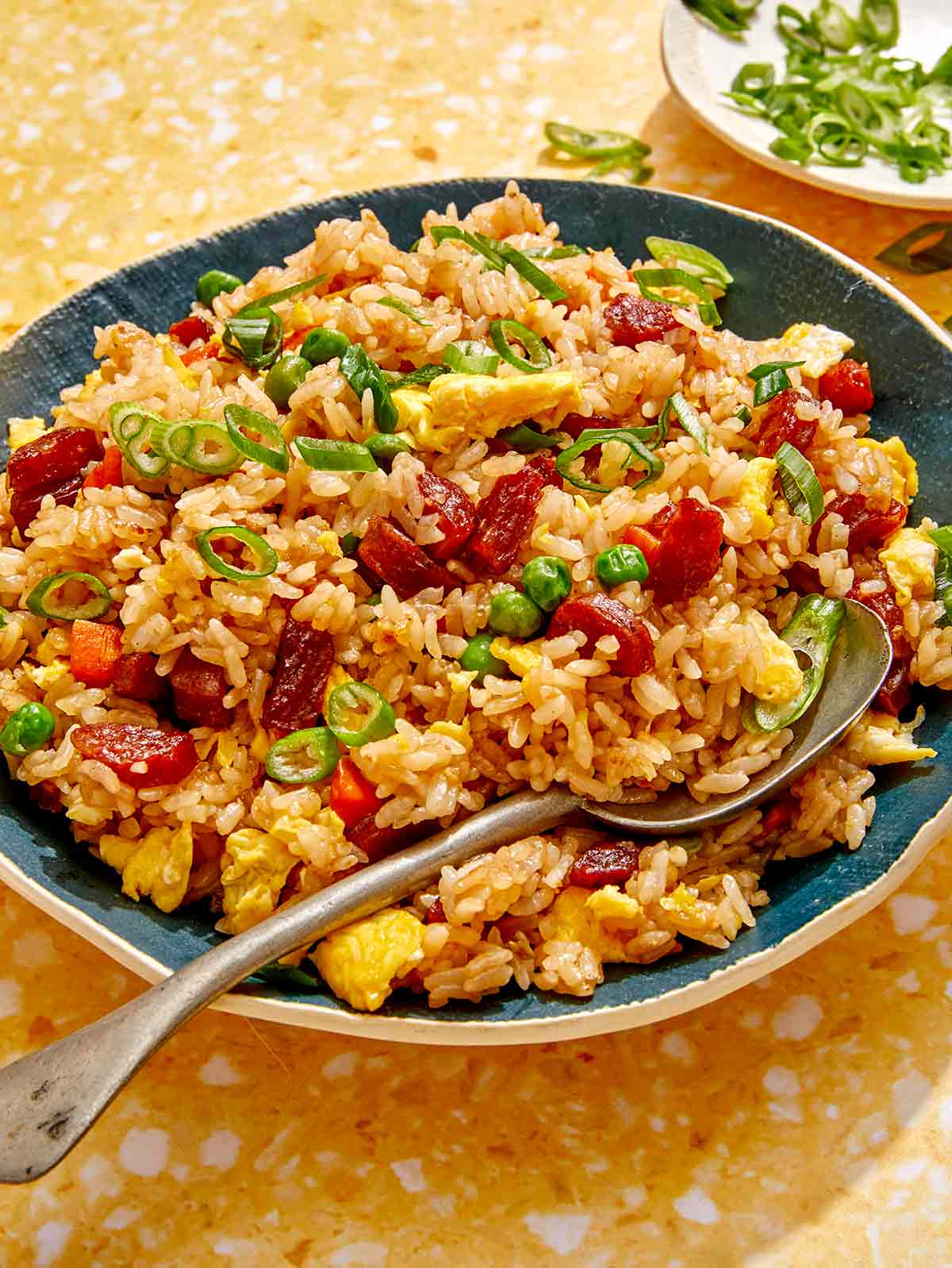 Fried rice in a bowl with a spoon in it. 