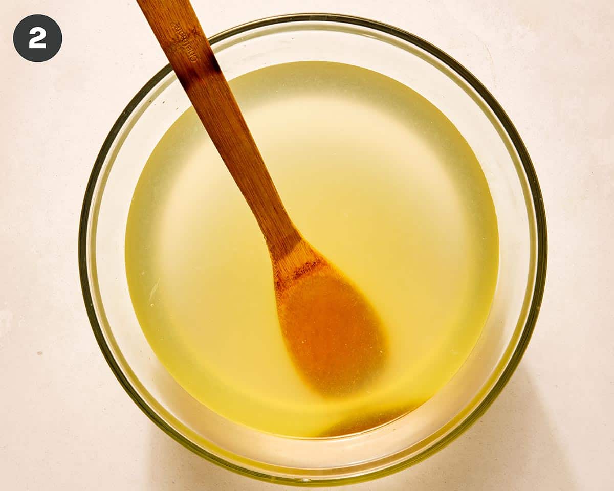 How to make lemonade in a glass bowl with a wooden spoon.