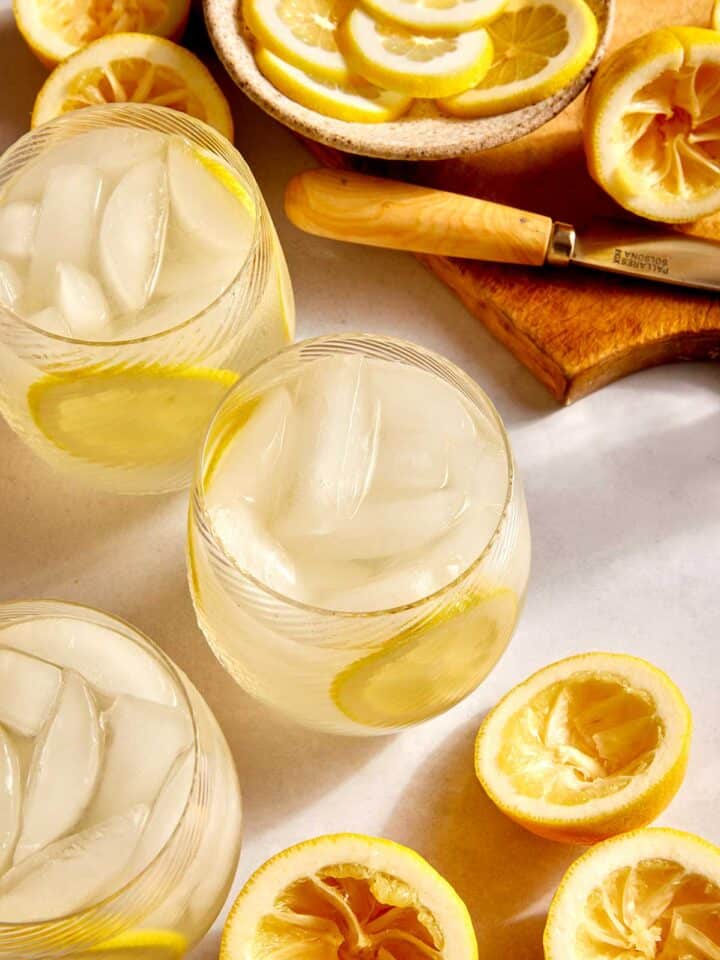 Classic lemonade recipe in glasses with ingredients around the side.