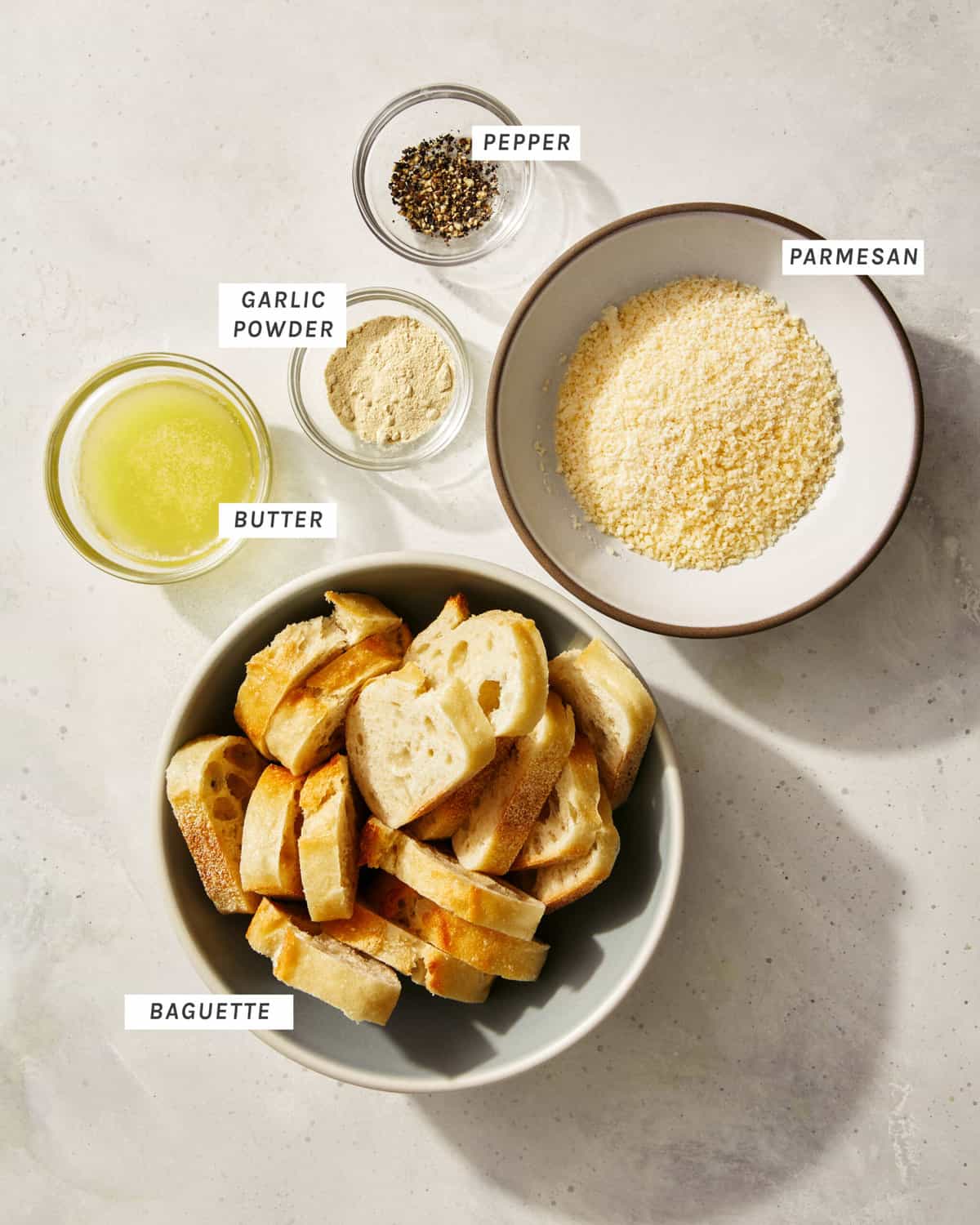 Parmesan crusted crostini ingredients on a kitchen counter. 