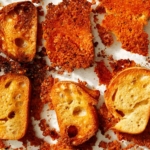 Parmesan crusted crostini in a baking dish.