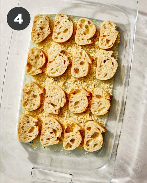 Parmesan crusted crostini over a parmesan mixture ready to be baked.
