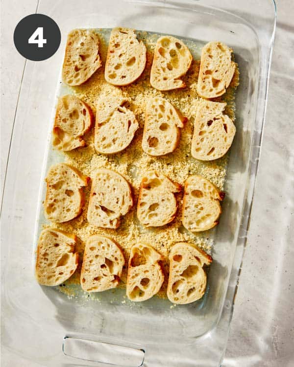 Parmesan crusted crostini over a parmesan mixture ready to be baked. 