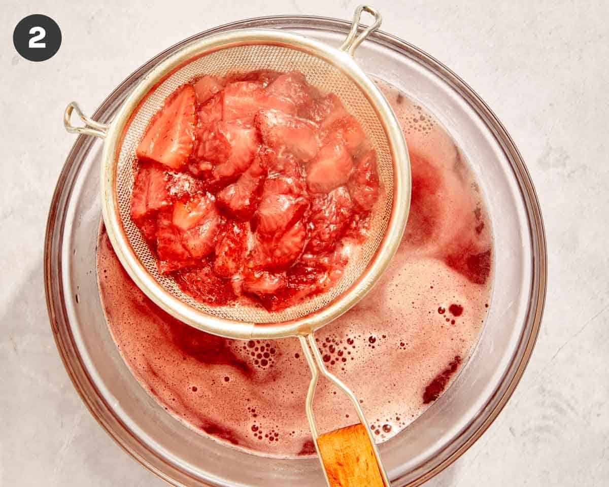 Cooked strawberries being strained. 