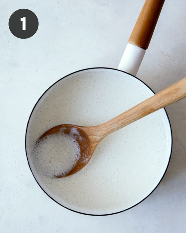 Milk heated up in a pot to make banana pudding.