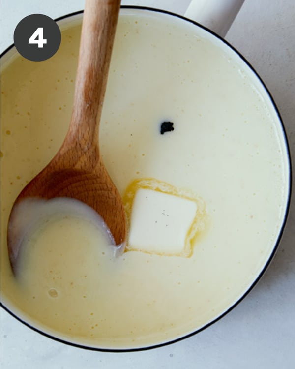 Adding butter and vanilla into a pot to make banana pudding recipe.