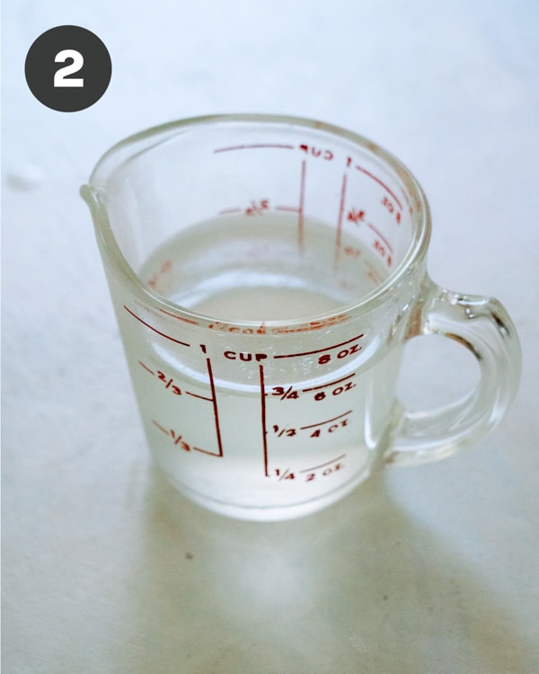 Glass measuring cup with pasta water.