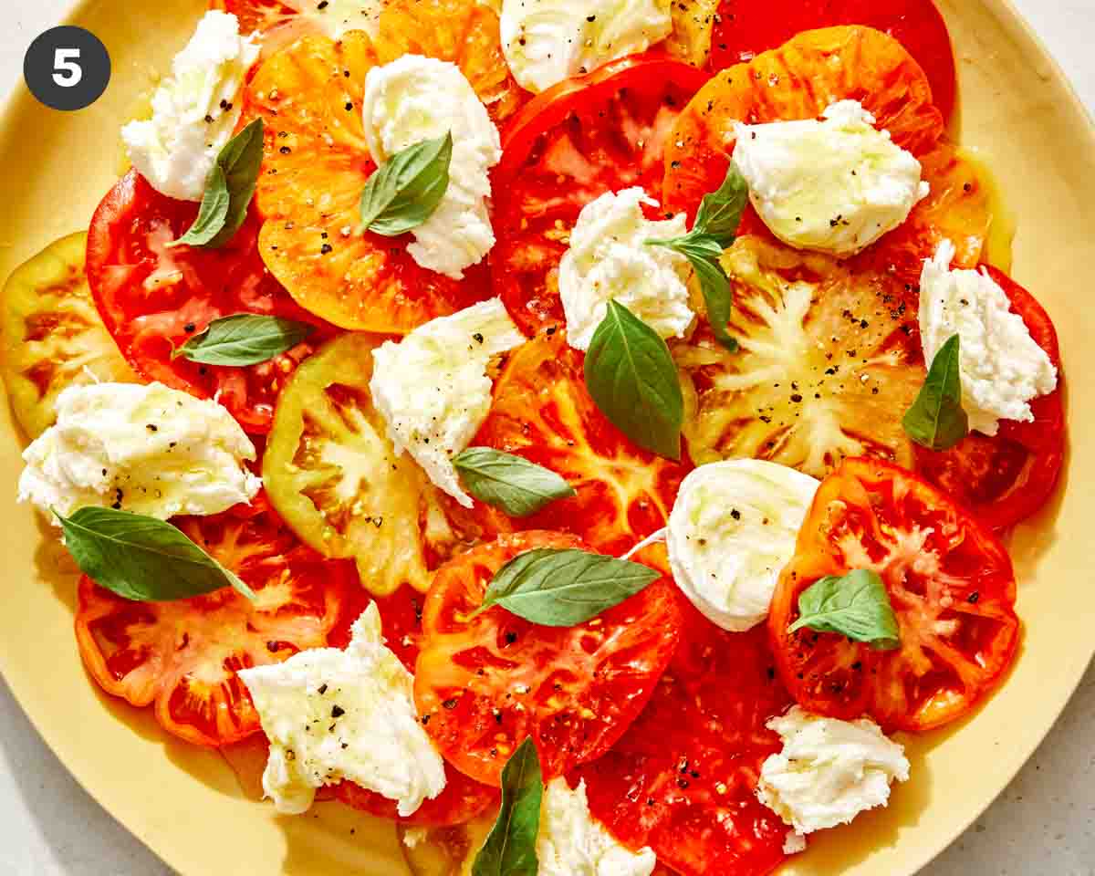 Caprese salad on a platter with mozzarella and basil.
