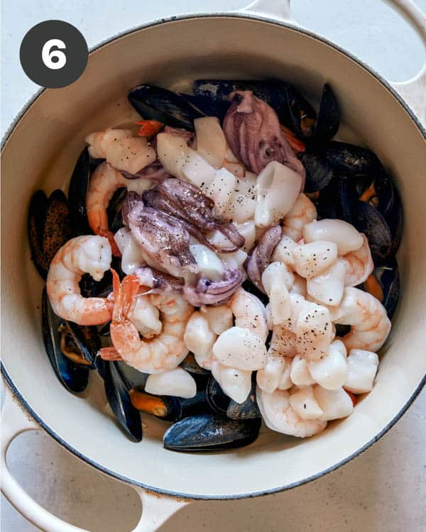 Seafood being cooked in a pot to make frutti di mare.