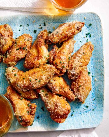 Parmesan dusted chicken wings on a platter.