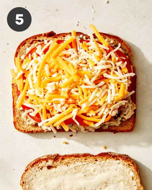 Tuna melt with cheese on top of the bread ready to be toasted.