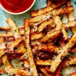 Air fryer french fries on a platter with ketchup and mayo.