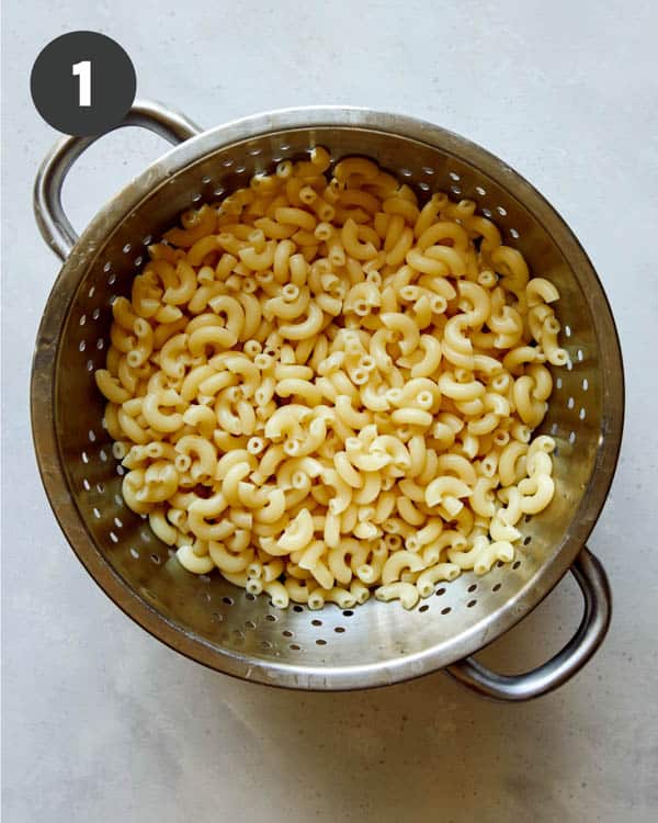 Cooked elbow macaroni in a colander.